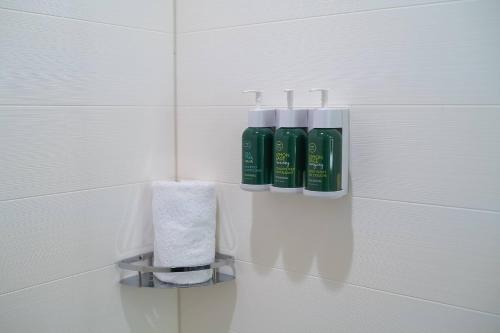 a bathroom with three bottles ofodorizers and a towel at SpringHill Suites by Marriott Cape Canaveral Cocoa Beach in Cape Canaveral
