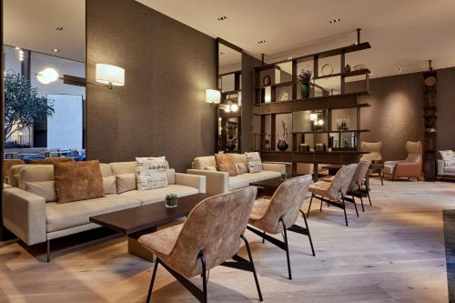 a living room with couches and tables and chairs at The Westin Grand Frankfurt in Frankfurt/Main