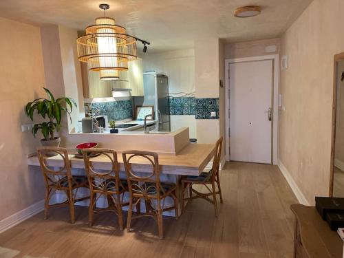 una cucina con tavolo e sedie in legno di Maravilloso apartamento en primera línea de playa. a Torreguadiaro