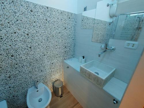 a white bathroom with a sink and a toilet at Borgo Sciugolo in Baselice