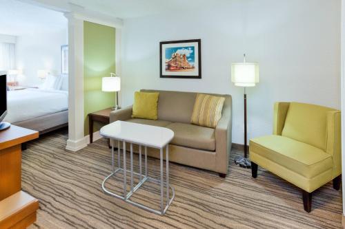 a hotel room with a couch and a chair and a bed at SpringHill Suites Minneapolis West St. Louis Park in Saint Louis Park