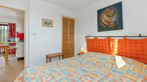 a bedroom with a bed with an orange head board at Port Lano- 172- Appart bonne exposition- 4 pers in Cap d'Agde