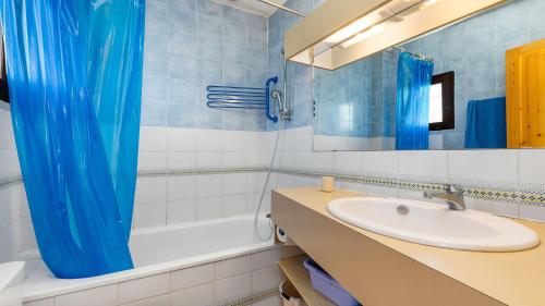 uma casa de banho com um lavatório e uma cortina de chuveiro azul em Port Lano- 172- Appart bonne exposition- 4 pers em Cap d'Agde