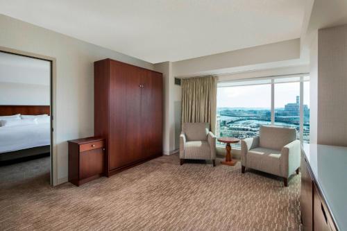 a hotel room with a bed and two chairs and a window at The Westin Boston Seaport District in Boston