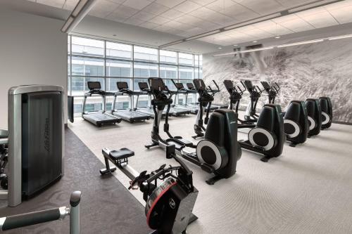 a gym with a row of tread machines and a wall of windows at The Westin Boston Seaport District in Boston