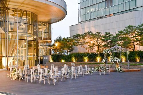 a group of tables and chairs in front of a building at Courtyard By Marriott Seoul Times Square in Seoul