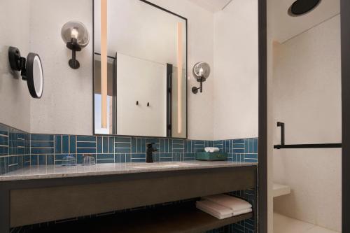 a bathroom with a sink and a mirror at Four Points by Sheraton Tianjin National Convention and Exhibition Center in Tianjin