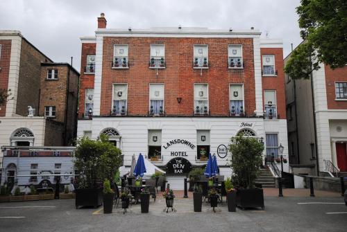 a large white building with blue umbrellas in front of it at The Lansdowne Hotel in Dublin