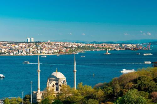 a building on a hill next to a body of water at The Ritz-Carlton, Istanbul at the Bosphorus in Istanbul