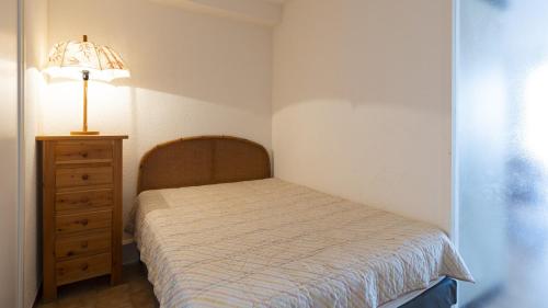 - une chambre avec un lit, une lampe et une commode dans l'établissement Les Indes Galantes- 299- Studio vue mer- 4 pers, au Cap d'Agde