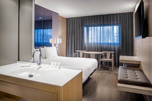 a hotel room with a bed and a sink at AC Hotel Sants by Marriott in Barcelona