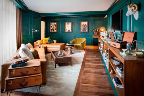 uma sala de estar com paredes verdes e um sofá em The Elizabeth Hotel, Autograph Collection em Fort Collins