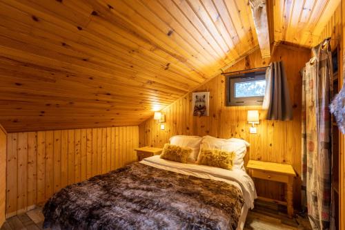 une chambre avec un lit dans une cabane en bois dans l'établissement Chalet les Lupins Bleus au pied des pistes Font-Romeu Pyrénées 2000, à Bolquère-Pyrénées 2000