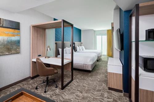 グリーンビルにあるSpringHill Suites by Marriott Greenville Downtownのベッド2台とデスクが備わるホテルルームです。