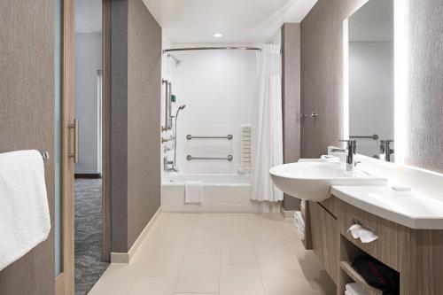 格林維爾的住宿－SpringHill Suites by Marriott Greenville Downtown，带浴缸、水槽和淋浴的浴室