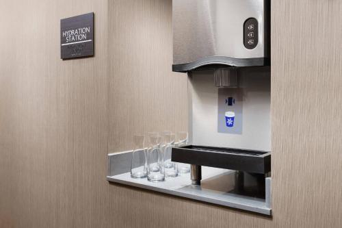 a coffee machine with wine glasses on a shelf at AC Hotel by Marriott New York Times Square in New York