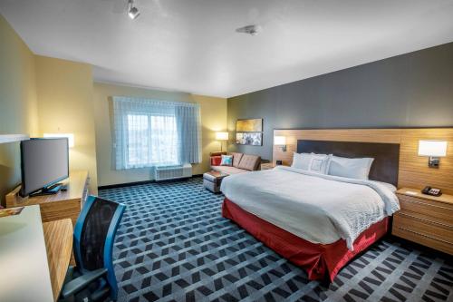 Habitación de hotel con cama y TV en TownePlace Suites by Marriott Toledo Oregon, en Oregon