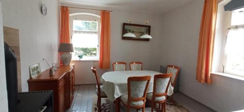 a dining room with a table and chairs and a window at OK FERIEN - Altes Bahnhaus in Muldenhammer