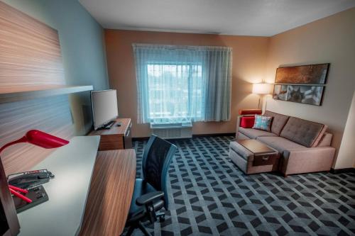 a hotel room with a couch and a chair and a desk at TownePlace Suites by Marriott Toledo Oregon in Oregon
