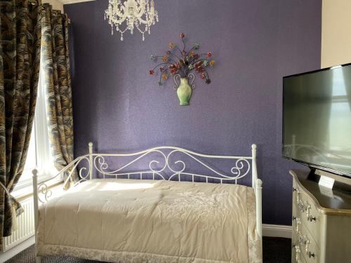 a purple bedroom with a bed with a vase on the wall at Atlanta Guest House in Eastbourne