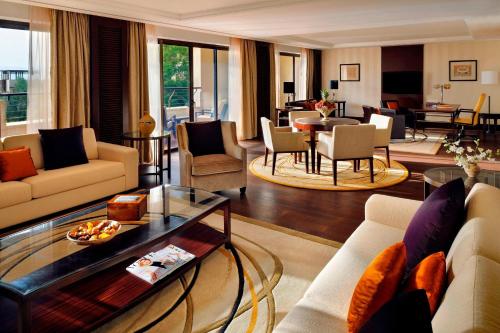 a living room with couches and a dining room at Dead Sea Marriott Resort & Spa in Sowayma