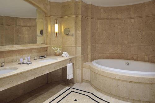 a bathroom with two sinks and a bath tub at Dead Sea Marriott Resort & Spa in Sowayma
