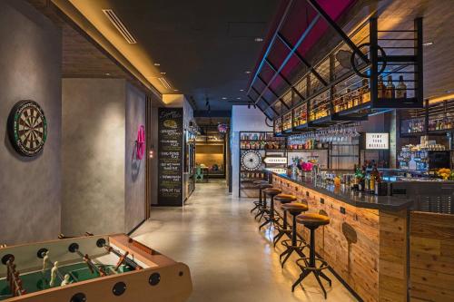 a bar in a restaurant with a pool table at MOXY Osaka Honmachi in Osaka