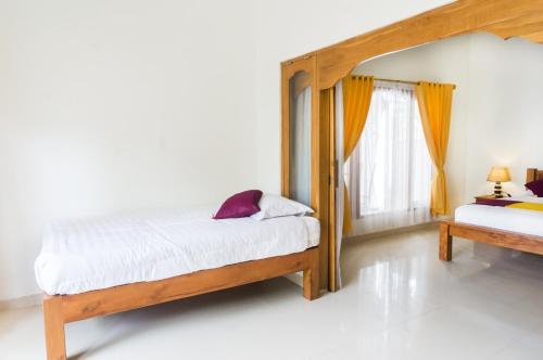 a bedroom with two beds and a window at Nusa Indah Bungalow in Nusa Lembongan
