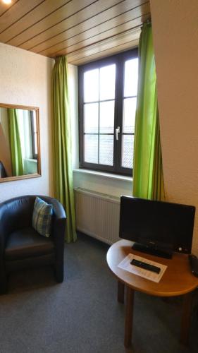 a living room with a computer on a table and a window at Hotel Burg Breuberg in Höchst im Odenwald