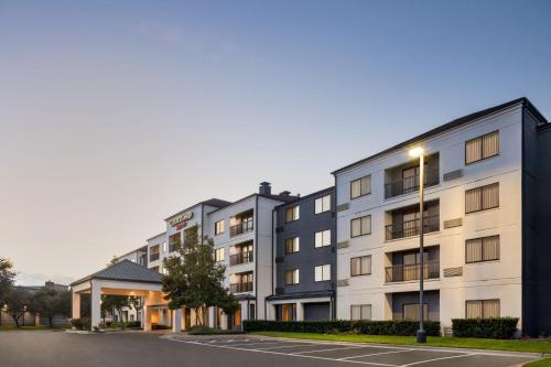 a row of apartment buildings with a parking lot at Courtyard Houston Sugar Land/Stafford in Stafford