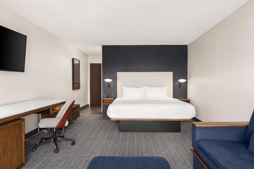a hotel room with a bed and a desk at Courtyard Houston Sugar Land/Stafford in Stafford