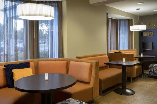 a waiting room with couches and tables and windows at Courtyard Houston Sugar Land/Stafford in Stafford