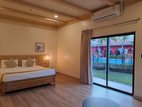 een slaapkamer met een bed en een grote glazen schuifdeur bij PM Lake Mabprachan Pattaya in Ban Pong