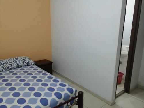 a small bedroom with a bed and a mirror at Guayacan Hostel in Cali
