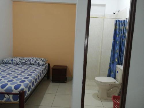 a bedroom with a bed and a toilet and a shower at Guayacan Hostel in Cali