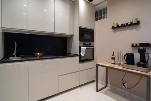 - une cuisine avec des placards blancs et un comptoir avec un évier dans l'établissement MAISON GAMBETTA, à Deauville