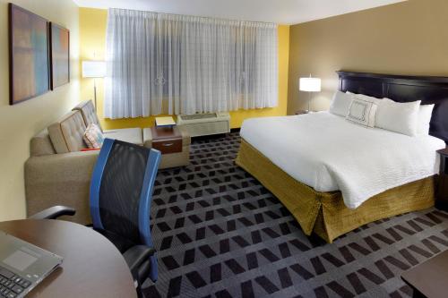 a hotel room with a large bed and a desk at TownePlace Suites Joplin in Joplin