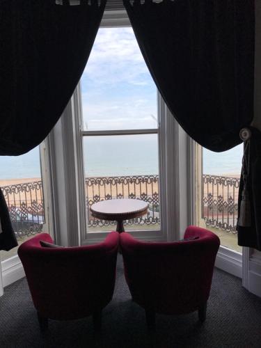une chambre avec deux chaises, une table et une fenêtre dans l'établissement Atlanta, à Eastbourne