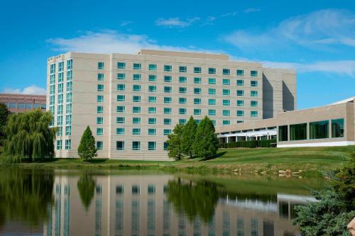 un gran edificio blanco con un lago frente a él en Chicago Marriott Southwest at Burr Ridge, en Burr Ridge