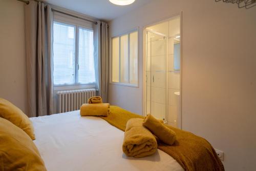 1 dormitorio con 1 cama con 2 toallas en MAISON GAMBETTA en Deauville