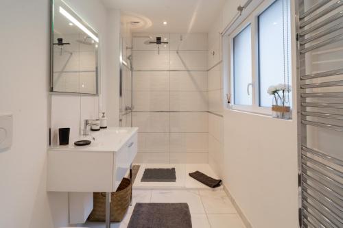 Baño blanco con lavabo y espejo en MAISON GAMBETTA en Deauville