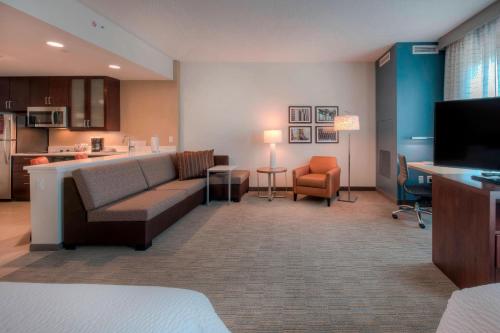 a living room with a couch and a kitchen at Residence Inn by Marriott Raleigh Downtown in Raleigh