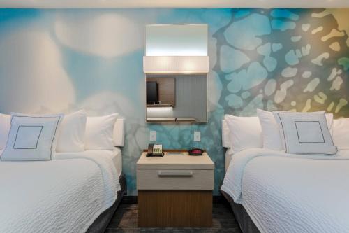 a hotel room with two beds and a mirror at Courtyard by Marriott Dallas Midlothian at Midlothian Conference Center in Midlothian