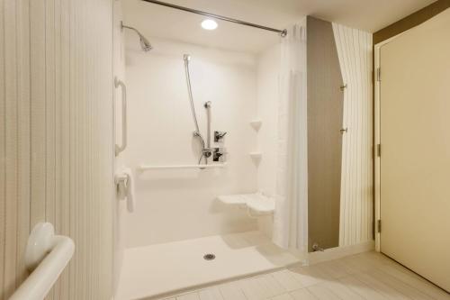 La salle de bains blanche est pourvue d'une douche et de toilettes. dans l'établissement Courtyard by Marriott Dallas Midlothian at Midlothian Conference Center, à Midlothian