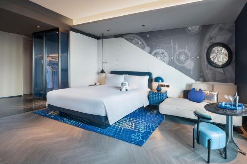 a bedroom with a white bed and a blue rug at W Changsha in Changsha