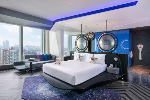 a bedroom with a large bed and a living room at W Changsha in Changsha