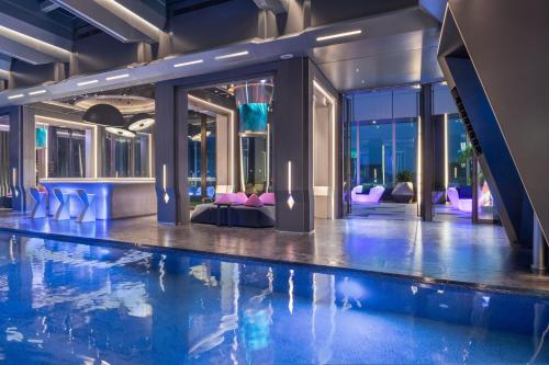a swimming pool in a hotel lobby with purple chairs at W Changsha in Changsha