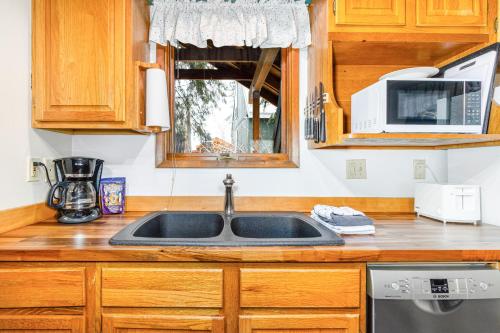 a kitchen with a sink and a microwave at Snowbird Chalet #5 in Girdwood