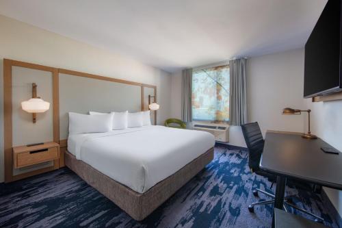 ein Hotelzimmer mit einem großen Bett und einem Schreibtisch in der Unterkunft Fairfield Inn by Marriott JFK Airport in Queens