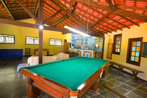 a pool table in the middle of a room at Vila da Sol Itaipava casas e estúdios in Itaipava